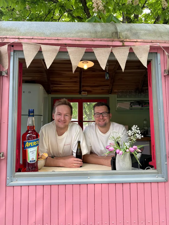 Die Spritzbuben lehnen im Fenster des pinken Bauwagens